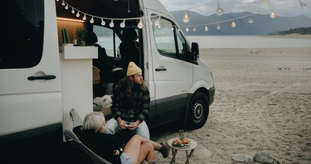 Image of a couple sitting outside their camper van