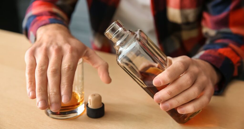 Image of a man with his hand covering a glass of alcohol.