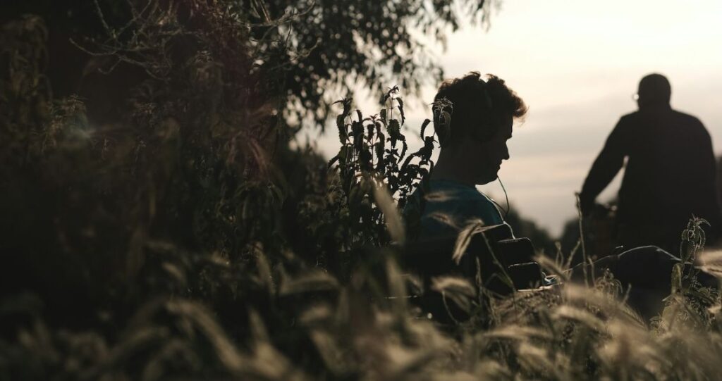 Silhoutte of two men with tree branches around