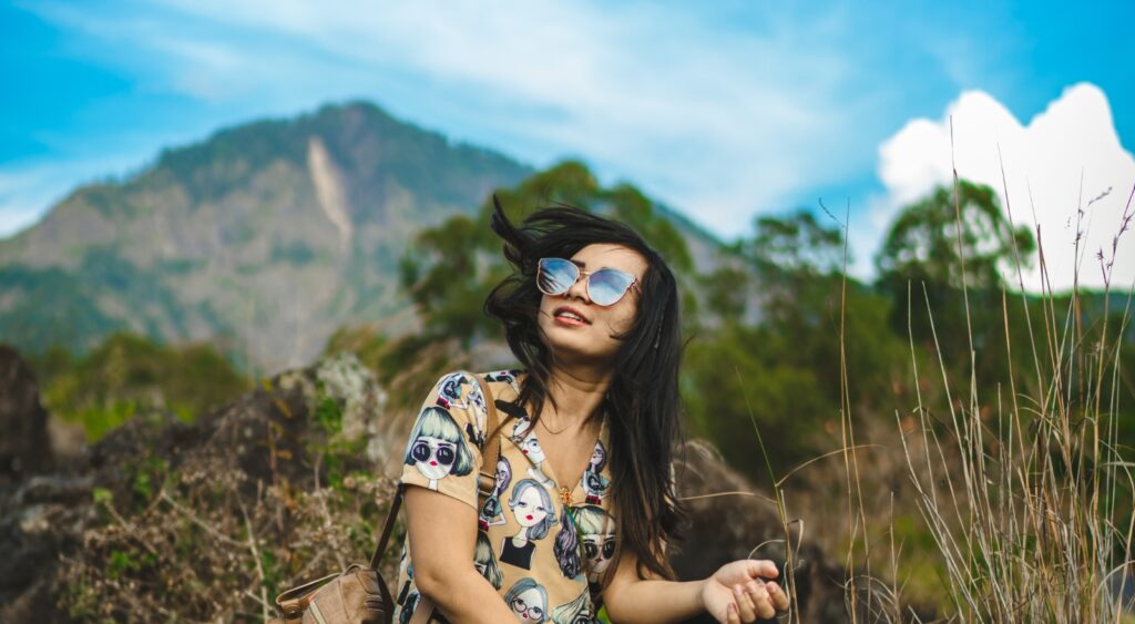 Happy woman sitting in the mountains