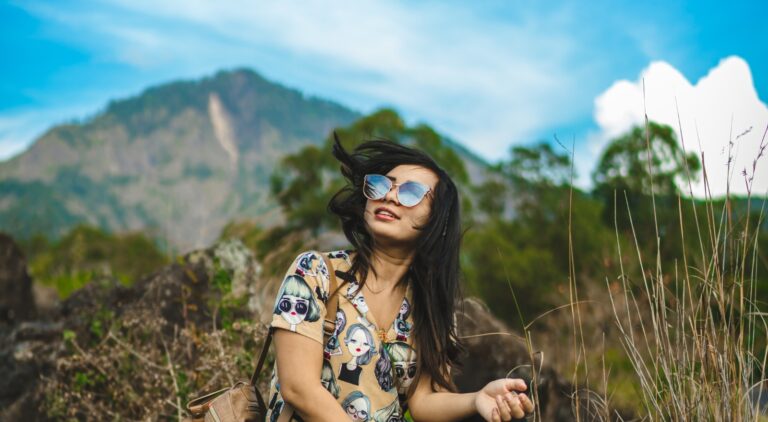 Happy woman sitting in the mountains