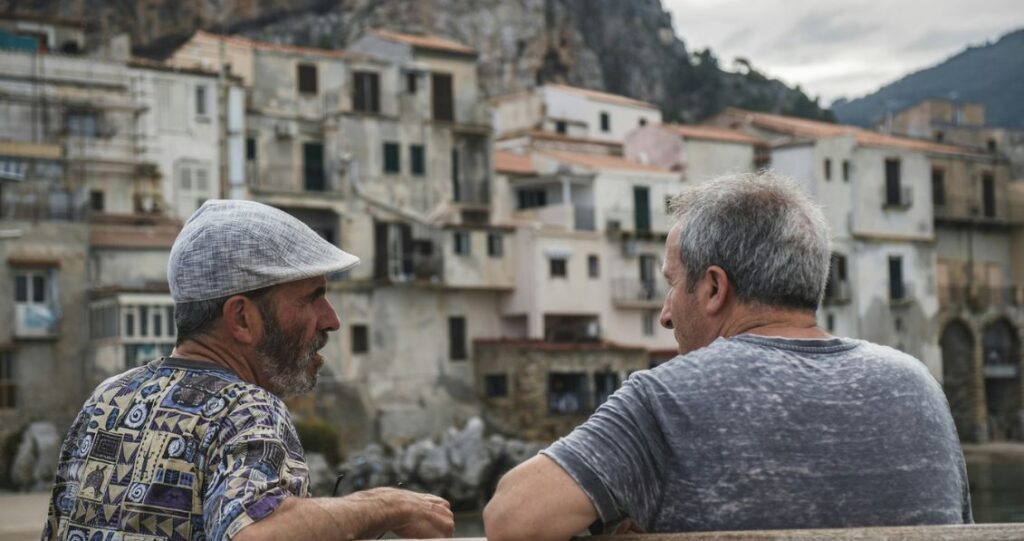 Two men talking on what looks like an old italian town